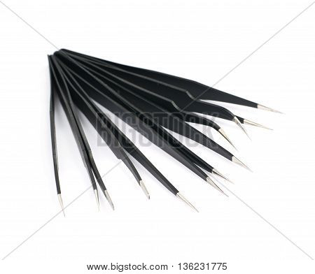 Pile of black metal anti-static tweezers tools isolated over the white background