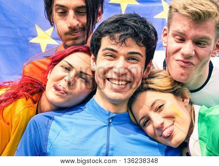 Funny faces group of friends taking selfie at football stadium - International soccer supporters party and fun moment before championship game - Concept of different nationalities people joy together