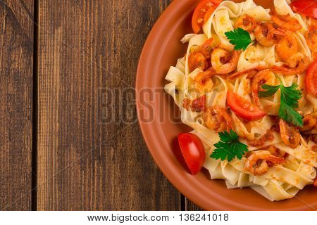 Fettuccine Pasta With Shrimp Tomatoes And Herbs. Wooden Background