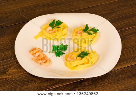 pasta decorated shrimp with parsley on a wooden background