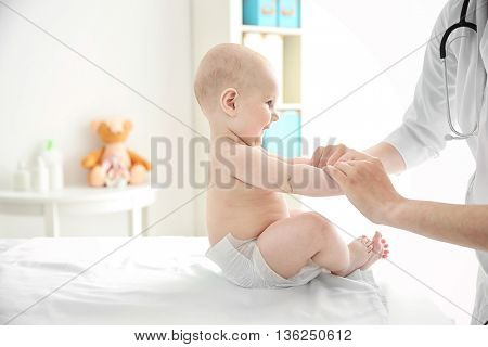 Doctor doing exercises with baby