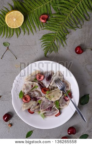 Cherry dumplings, made with wonton wrappers and cherries. Traditional russian cuisine recipe, Top view.