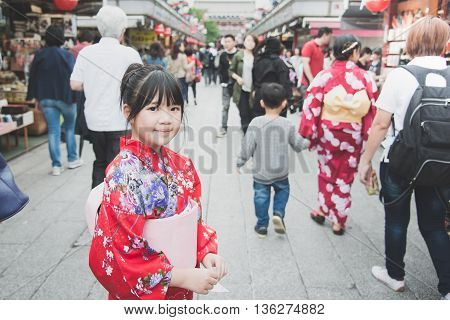 Beautiful Asian girl wearing red kimono walking in the city Asakusa Tokyo Japan.