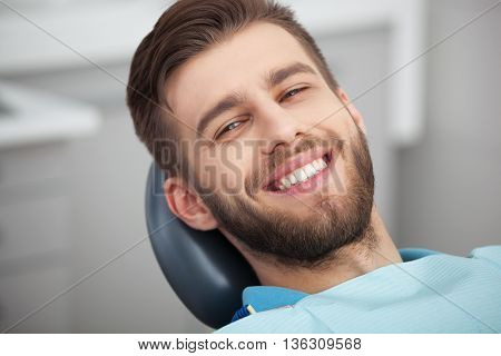 Portrait Of Happy Patient In Dental Chair.