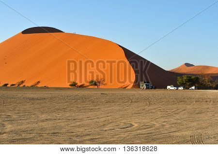 SOSSUSVLEI NAMIBIA - JAN 29 2016: Tourists climb Dune No.45 at sunrise most popular dune in the whole World Namibia Africa