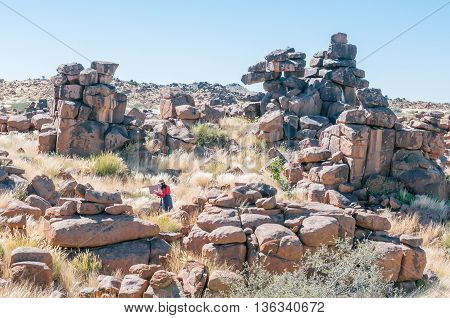 KEETMANSHOOP NAMIBIA - MAY 15 2011: An unidentified artist at work between rock formations at Giants playground near Keetmanshoop