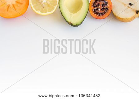 Persimmon Lemon avocado tamarillo pear border on a white background