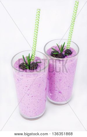Pudding with chia seeds granola and blackbery on a white background. Berry cocktail in a glass.