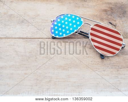 mirror glasses with american flag pattern on wooden background.4th of July concept.
