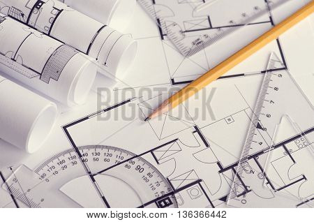 Toned and selective focus image.Several rolls of blueprints on an open blueprint
