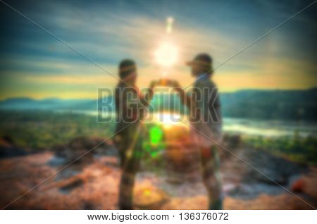 Abstract Blurred and soft photo of the lover standing on the hilltop during sunrise.
