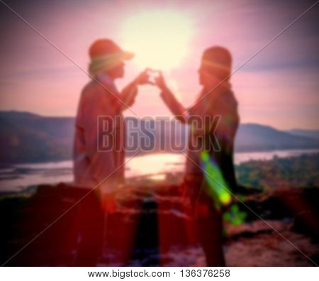 Abstract Blurred and soft photo of the lover standing on the hilltop during sunrise.