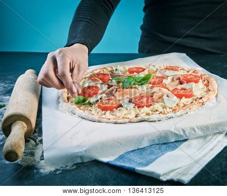 Closeup hand of baker making pizza at kitchen