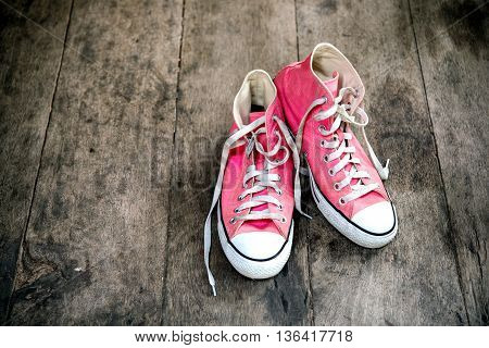 Pink sneakers on wooden floor vintage style