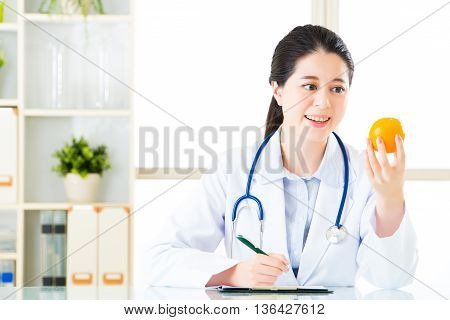 Young Asian Nutritionist Doctor Writing Diet Plan