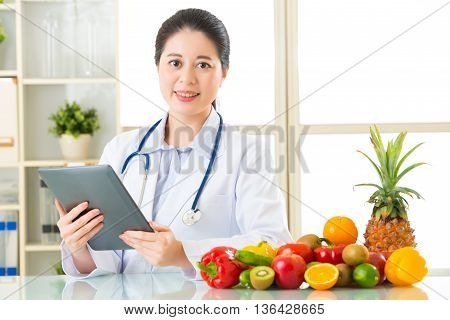 Doctor Nutritionist Using Digital Tablet With Fruits And Vegetable
