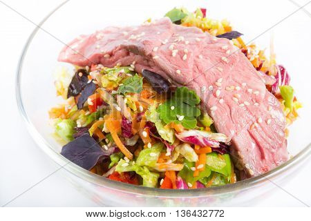 Roastbeef salad in a bowl on a white background