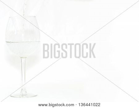 Drink being poured into a glass on white background on left hand side