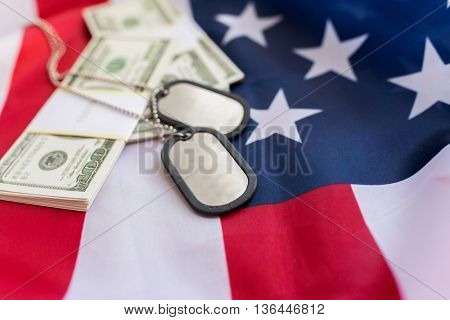 military forces, recruitment, financing and national service concept - close up of american flag, dollar money and military badges