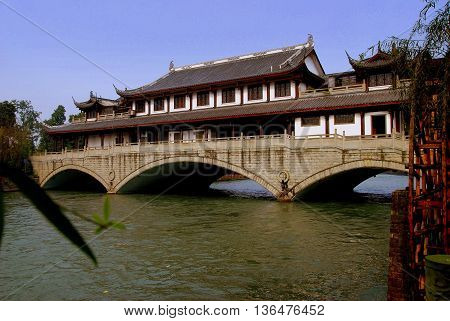 Sandaoyan China - November 10 2007: A vast hall with flying eave roofs built over the stone three span Yanqiao Bridge on the Baitiao River