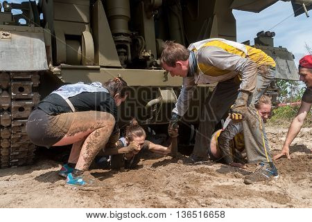 Tyumen, Russia - June 11, 2016: Race of Heroes project on the ground of the highest military and engineering school. Woman moves under tank Daria Shy. Caterpillar stage