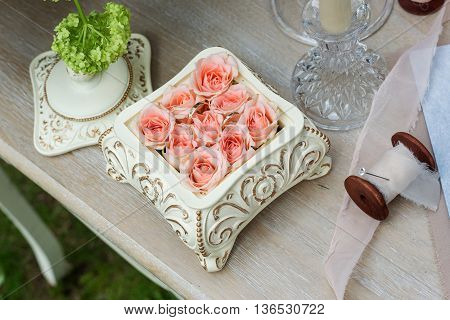 Pink roses in a ceramic box on the table, beautiful ribbons-2