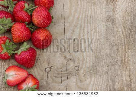 Scattered strawberries on wooden table (can be used as background, card)