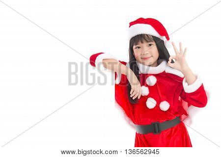 Little asian girl in in Santa Claus uniform showing ok sign with an empty banner isolated on white