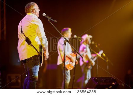 MOSCOW, RUSSIA - APR 24, 2015: Nikolay Fomenko with guitar singing in concert on stage of Crocus city hall at Secret band show. Rock and roll band Secret founded in 1982 in Leningrad.