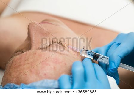 Beautician makes biorevitalization to young woman. The cosmetic procedures for the face. Beauty treatments in the spa salon. Facial Skin Care.