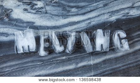 Melting caption made of ice cubes on dark marble