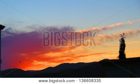 Silhouette at orange dawn clowds in village of Alora Andalusia