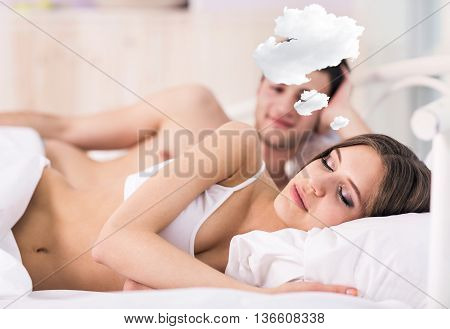 Woman with thoughts cloud sleeping in bed with her boyfriend