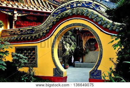 Pengzhou China - November 13 2013: A moon gate flanked by gardens leads into an inner courtyard at the Ci Ji Buddhist Temple
