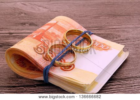 Two wedding rings and money. Dollars. Golden rings