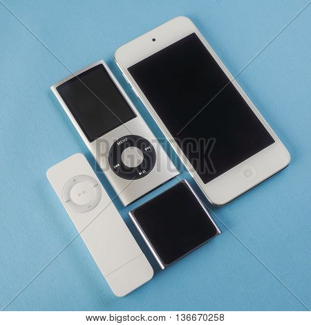 BERRY AUSTRALIA - June 20 2016 : A group of Apple iPods - iPod Nano 6th generation iPod Shuffle 1st generation iPod Touch 5th generation and iPod Nano 4th generation - on a plain blue background.