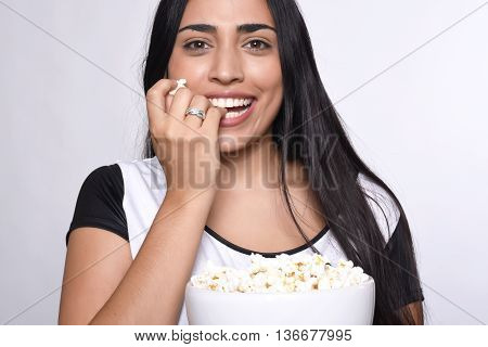 Young beautiful woman eating popcorn. Isolated white background