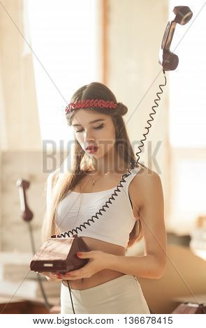 pretty woman talking on old telephone. Fashion model. Red lips. Sunny color.