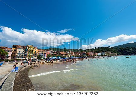 SAN TERENZO LERICI ITALY - JULY 10 2014: San Terenzo (St. Terenzo) beach crowded with bathers on a sunny day in july. The beach is located in the small village of San Terenzo tourist resort in Lerici in the Gulf of La Spezia Liguria Italy