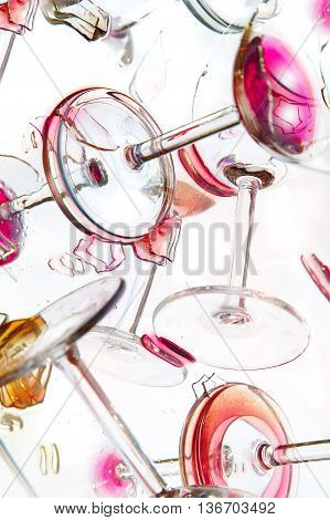 The broken glasses with wine on a smooth surface.