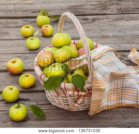 Basket with fresh apples on an old table