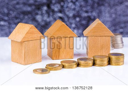 Wooden block houses and coin stacks in a row