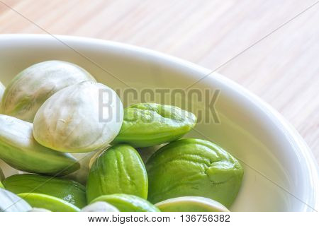 Parkia speciosa ( petai bitter bean twisted cluster bean stinker or stink bean) with white cup and spoon