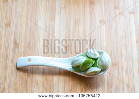 Parkia speciosa ( petai bitter bean twisted cluster bean stinker or stink bean) with white cup and spoon