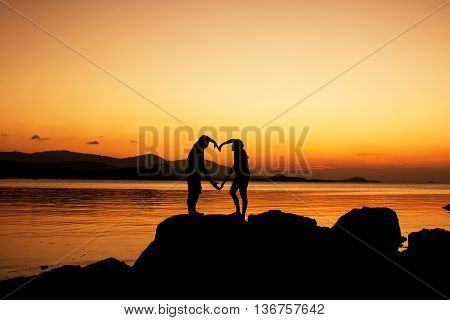 Silhouette of young couple in love at beachsunset background