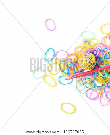Pile of multiple colorful rubber toy loom bands isolated over the white background, close-up crop fragment foreshortening