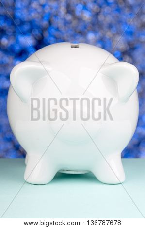Close up of a piggy bank on a blue blackground with blur