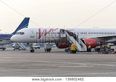 MOSCOW, RUSSIA - SEPTEMBER 26, 2014: Passengers climb the ladder into the plane Boeing 757 Vim airlines