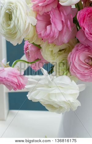 Pink and white ranunculus flowers bouquet in vase close up