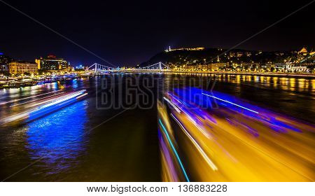 Cruise Boats Danube River Passing Under Chain Bridge Night Budapest Hungary. Elizabeth Bridge in the distance